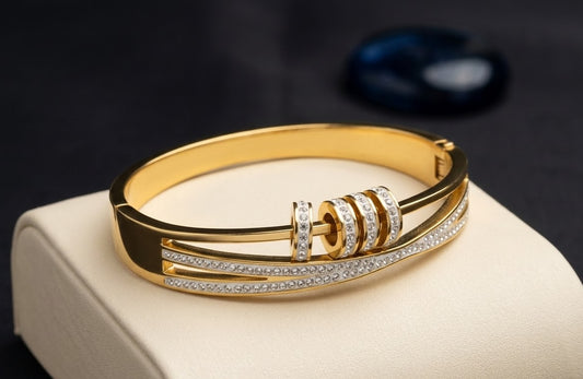 Gold-tone bangle bracelet with rows of sparkling clear stones